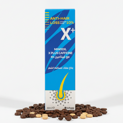 A boxed hair loss treatment product labeled 'ANTI-HAIR LOSS X+' stands upright on a white studio background, surrounded by scattered brown and beige tablets. The package is predominantly blue and white with yellow accents and Arabic text.